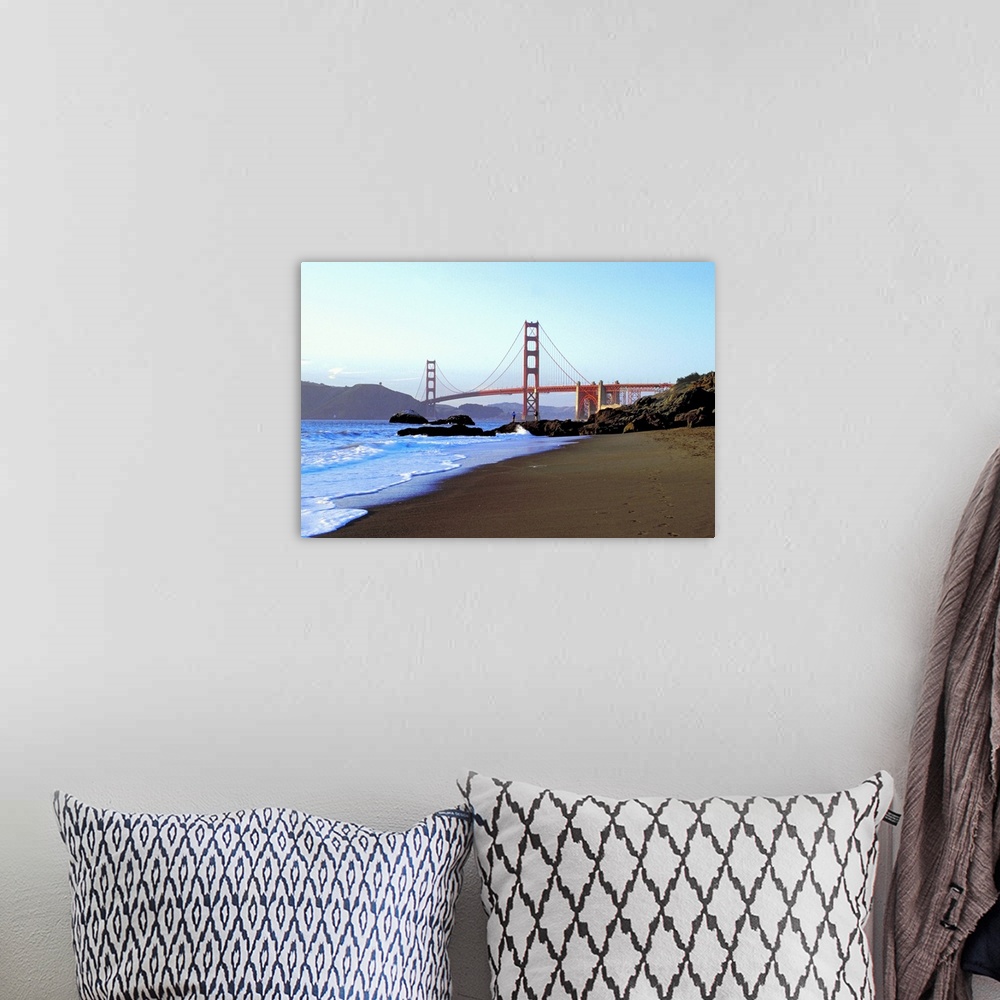 A bohemian room featuring Landscape photograph looking down the rocky shoreline toward the Golden Gate Bridge, beneath a bl...