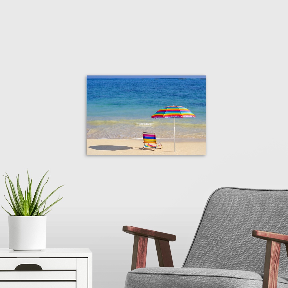 A modern room featuring Colorful beach chair and umbrella on the shoreline of a tropical beach, calm waves washing ashore...