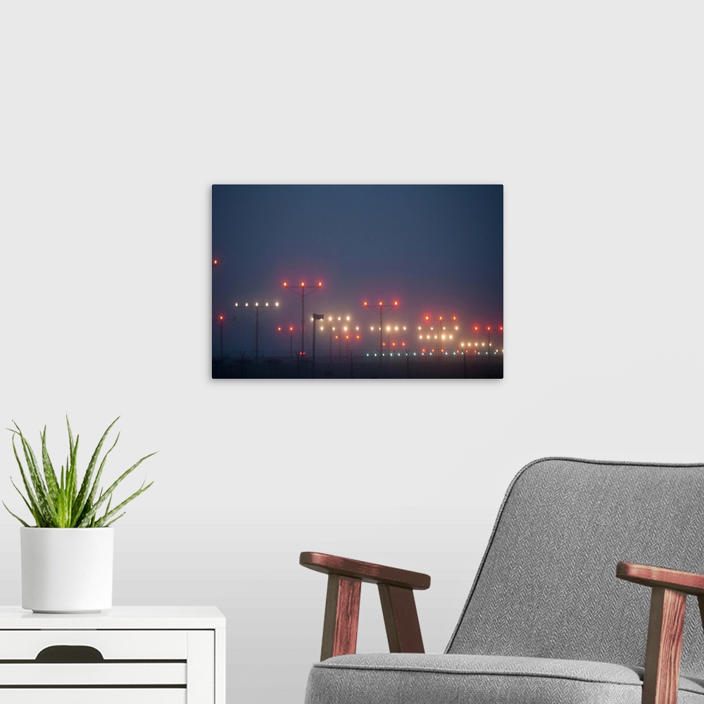A modern room featuring Colorful fogbound landing lights guide airplanes to runway.