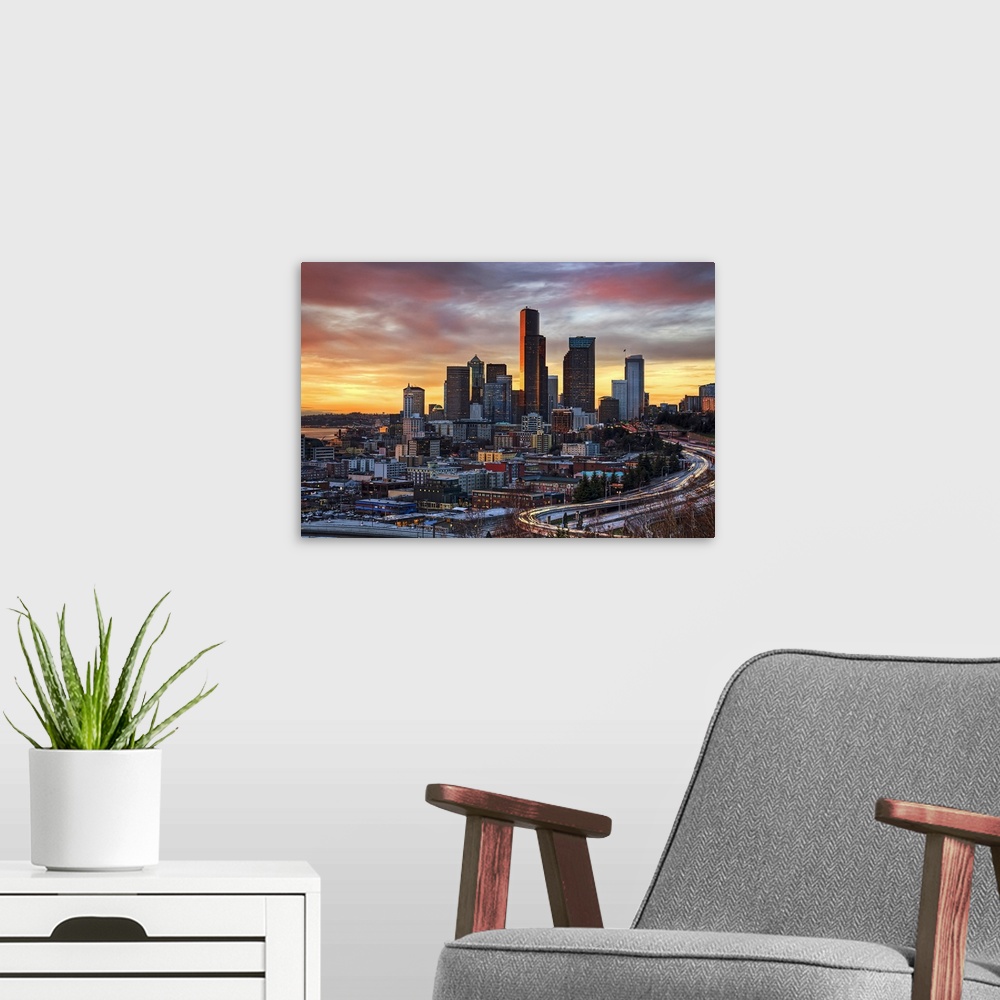 A modern room featuring Wall docor of the Seattle downtown buildings at sunset with cars lit up and driving on the highwa...