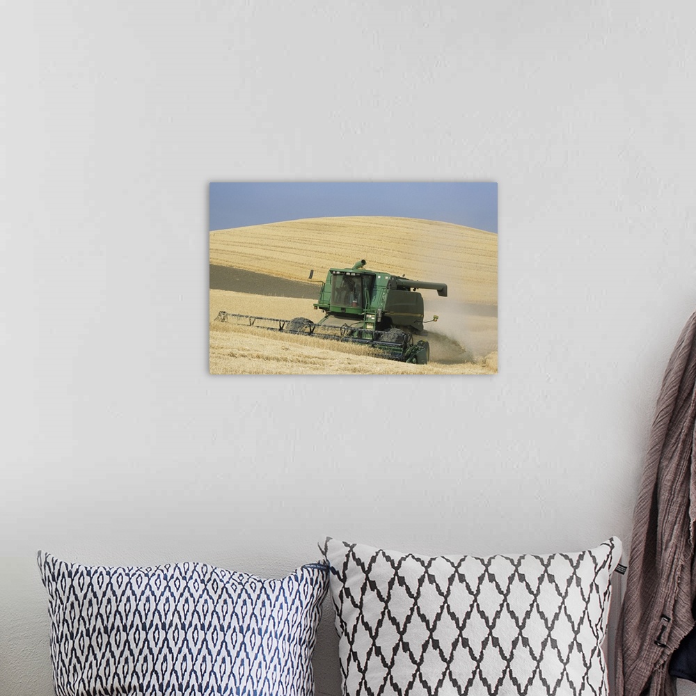 A bohemian room featuring Combine harvester harvesting golden wheat, late Summer, Washington State, USA