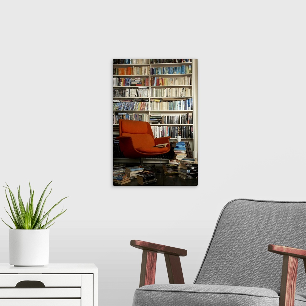 A modern room featuring comfortable chair surrounded by books