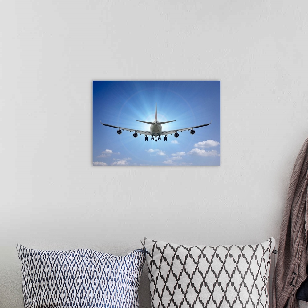 A bohemian room featuring Large airplane flies directly towards the sun on a clear blue day.