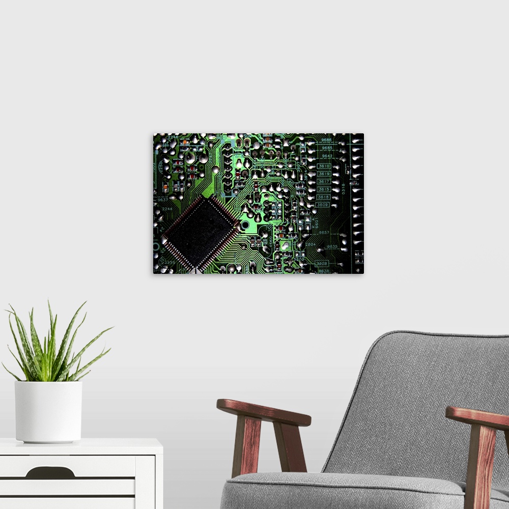 A modern room featuring Macro image of a green, silver, and black circuit board from inside a computer.