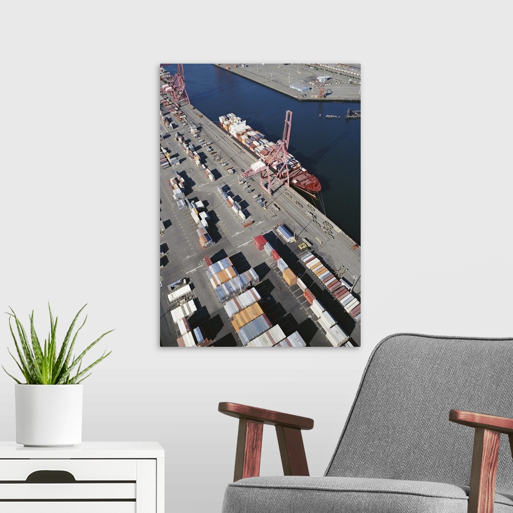 A modern room featuring Container ship alongside commercial dock, aerial view
