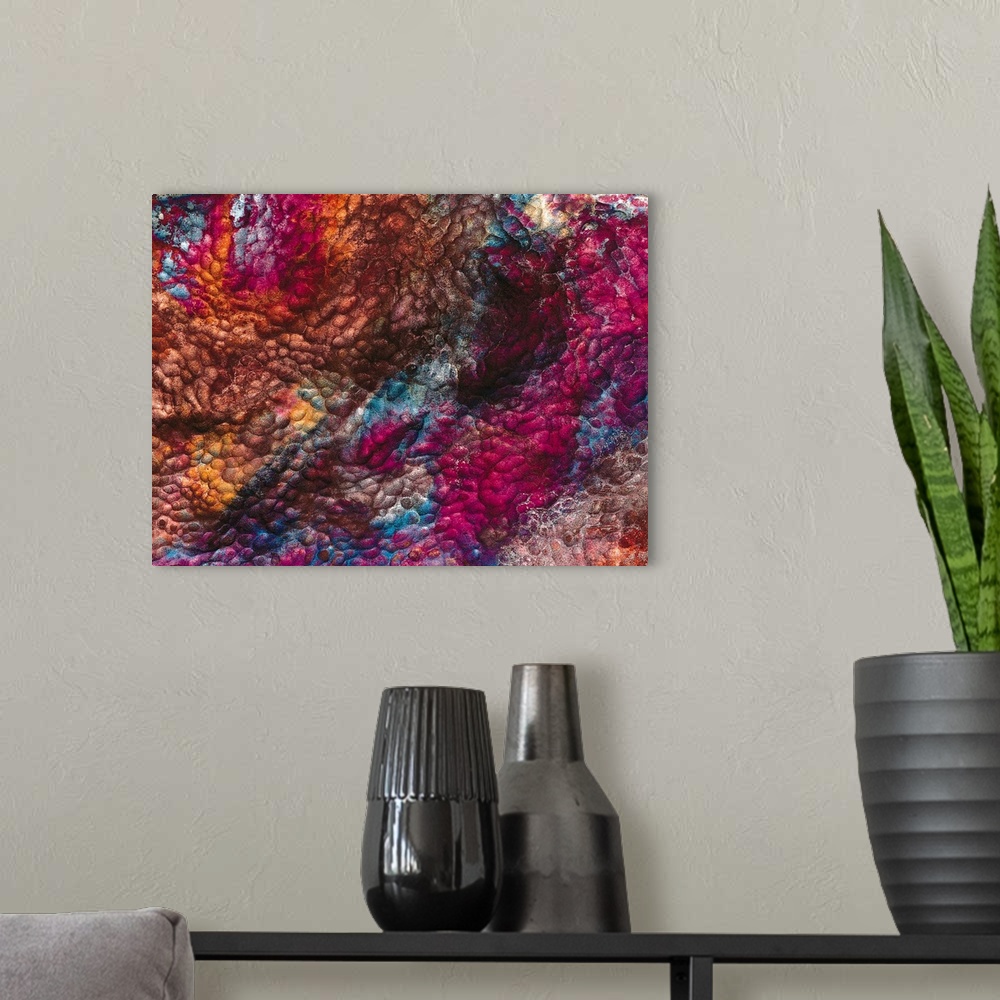 A modern room featuring Large, landscape, abstract wall hanging of a rough, bumpy texture in a variety of colors.