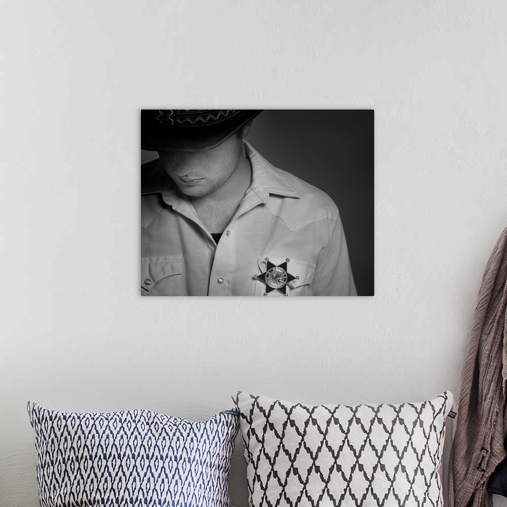 A bohemian room featuring Cowboy Looking Down Under Hat With Sheriff's Badge On Shirt