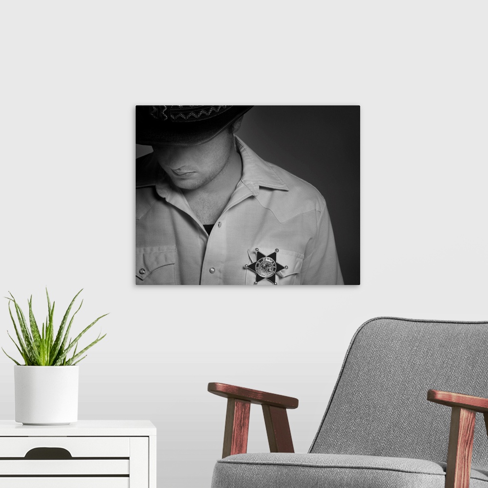 A modern room featuring Cowboy Looking Down Under Hat With Sheriff's Badge On Shirt