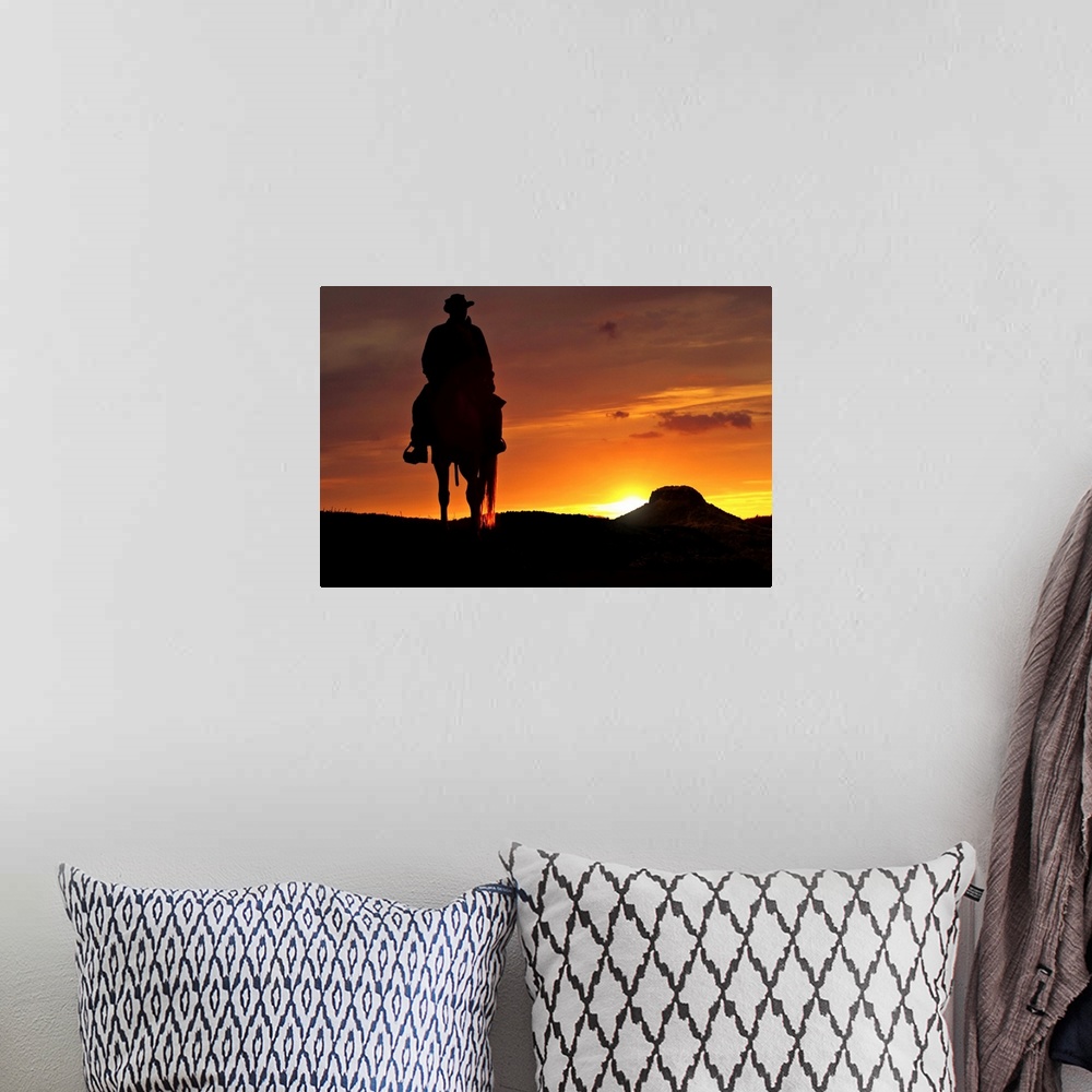 A bohemian room featuring Contour cowboy with horse in the sunset. In the background, a table mountain.