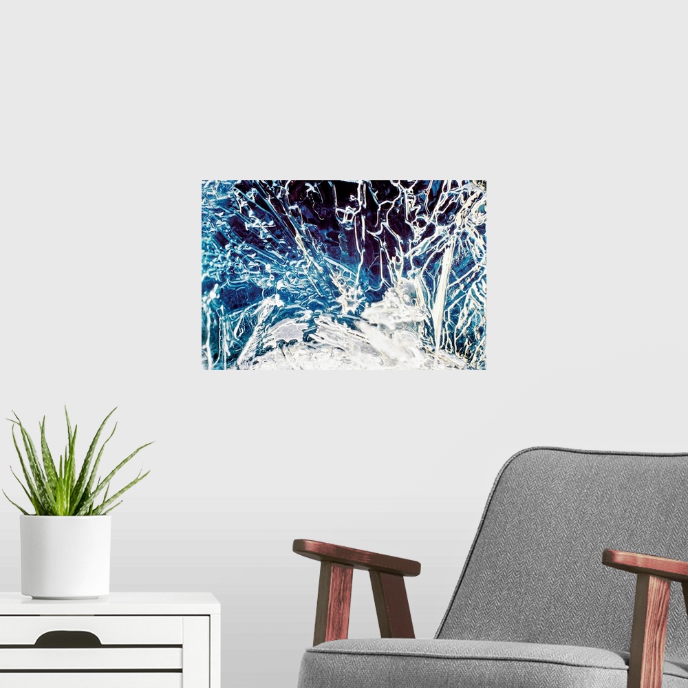 A modern room featuring Big, close up, landscape photograph of frozen water full of cracks and line in various directions.