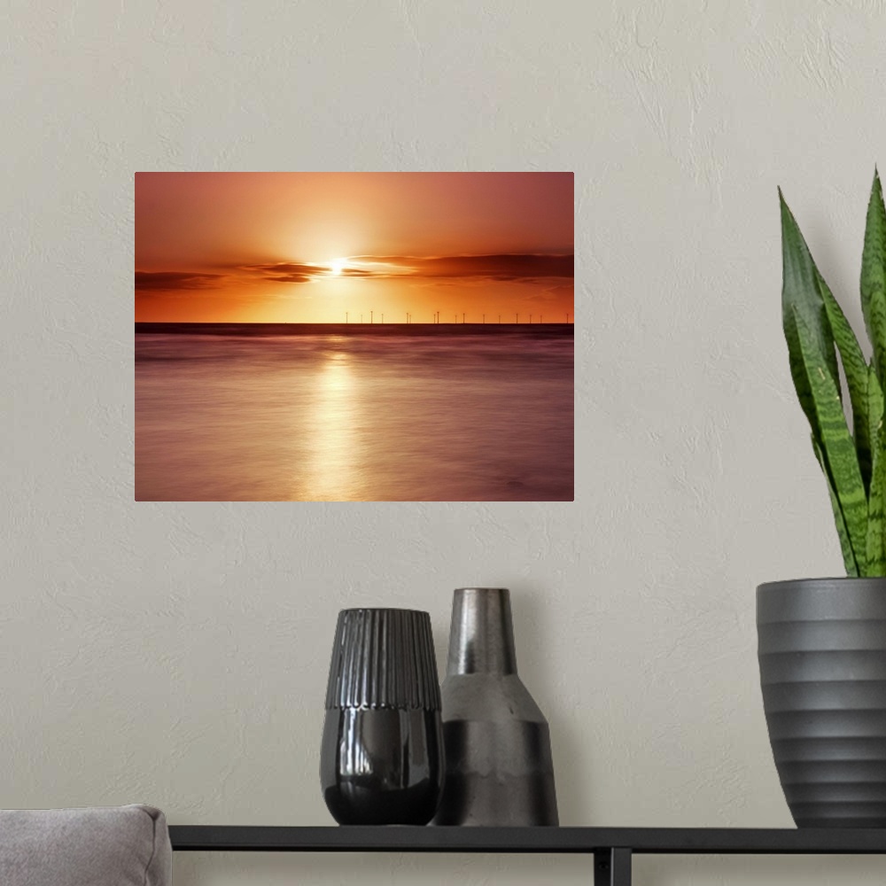 A modern room featuring Crosby beach,golden sunset with windfarm turbines and long exposure sea.