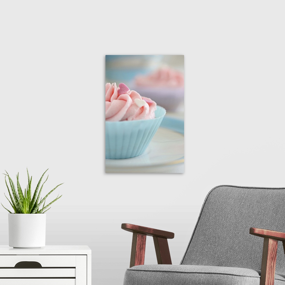 A modern room featuring Cupcakes with pink frosting and hearts of sugar.