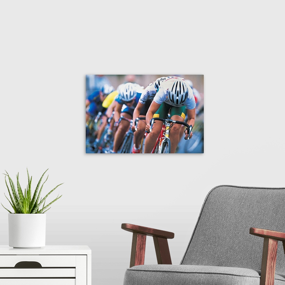 A modern room featuring Photograph of a several racers in a bicycle race hurrying towards the finish line, with their hea...
