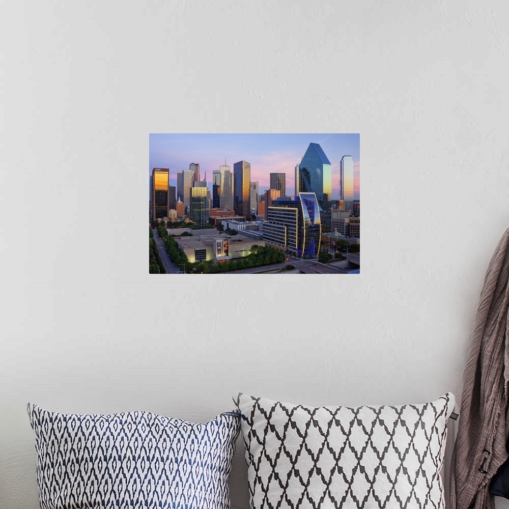 A bohemian room featuring Dallas cityscape with several modern skyscrapers reflecting the fading light from the sunset at t...