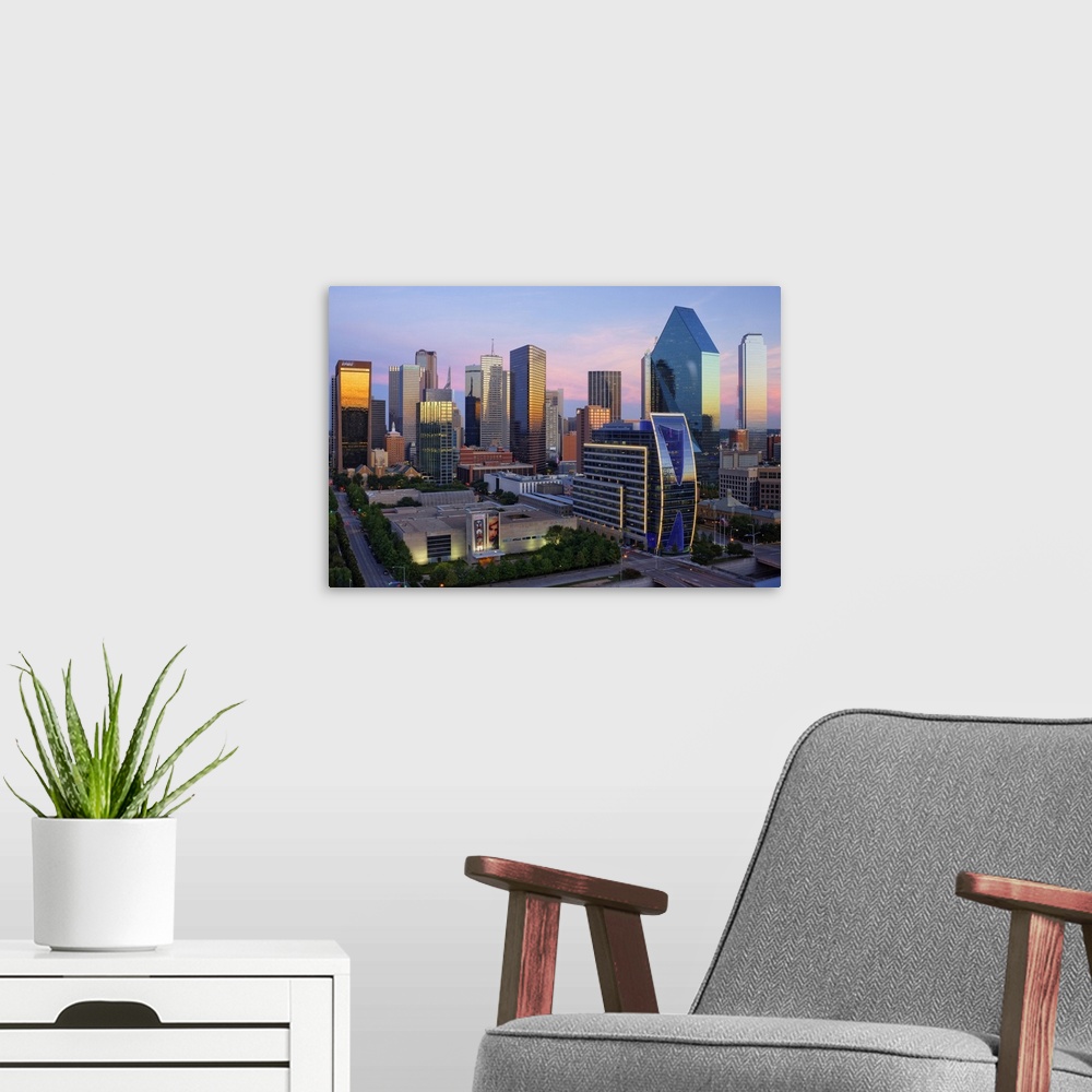 A modern room featuring Dallas cityscape with several modern skyscrapers reflecting the fading light from the sunset at t...
