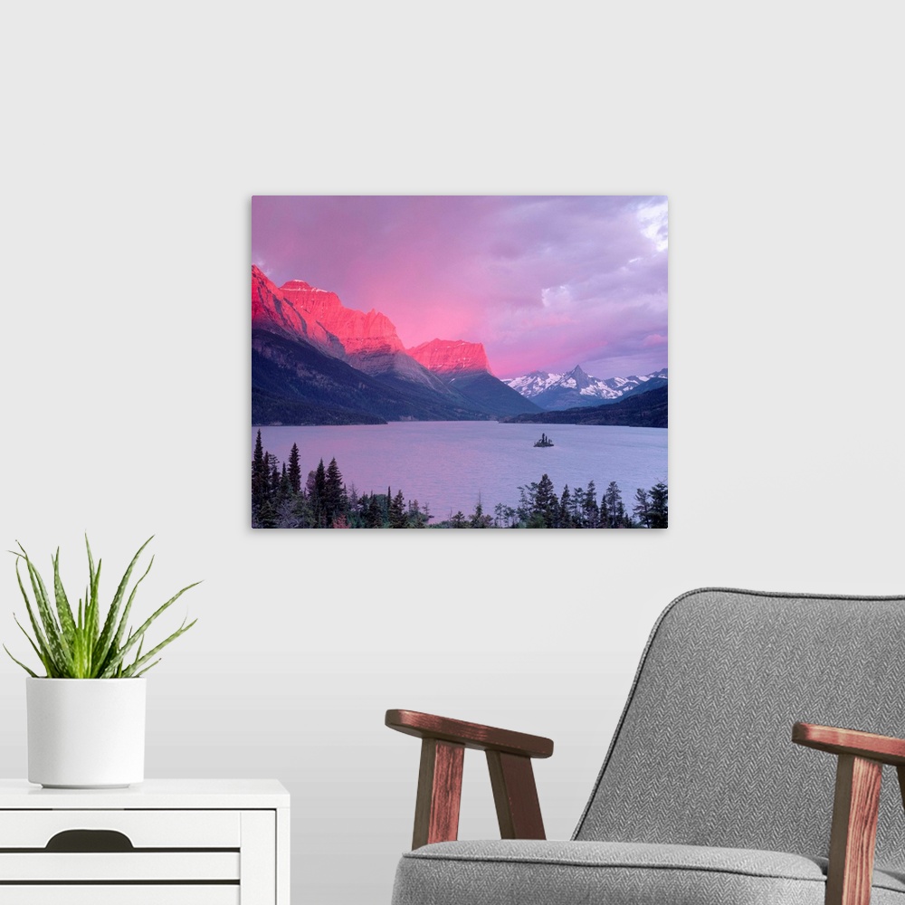 A modern room featuring Dawn sunlight illuminates the Rocky Mountains above Saint Mary Lake.