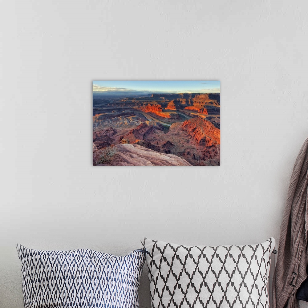A bohemian room featuring Large photo on canvas of red rock formations in Utah bathed in sunlight from a rising sun.