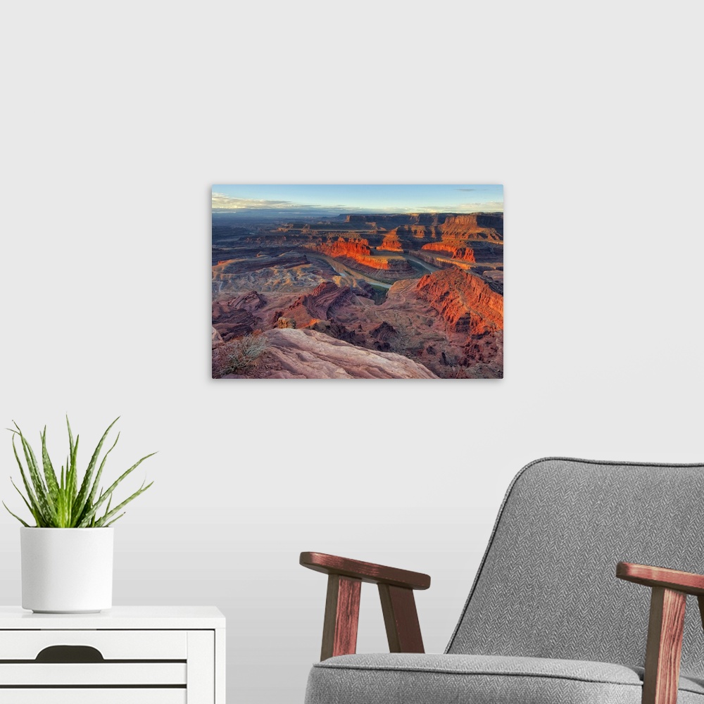 A modern room featuring Large photo on canvas of red rock formations in Utah bathed in sunlight from a rising sun.