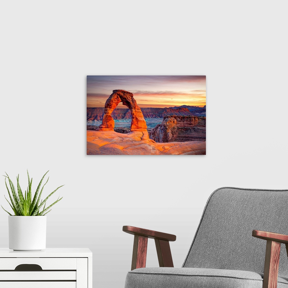 A modern room featuring This wall art for the home or office shows desert rock cliffs growing in the light of a sunset.