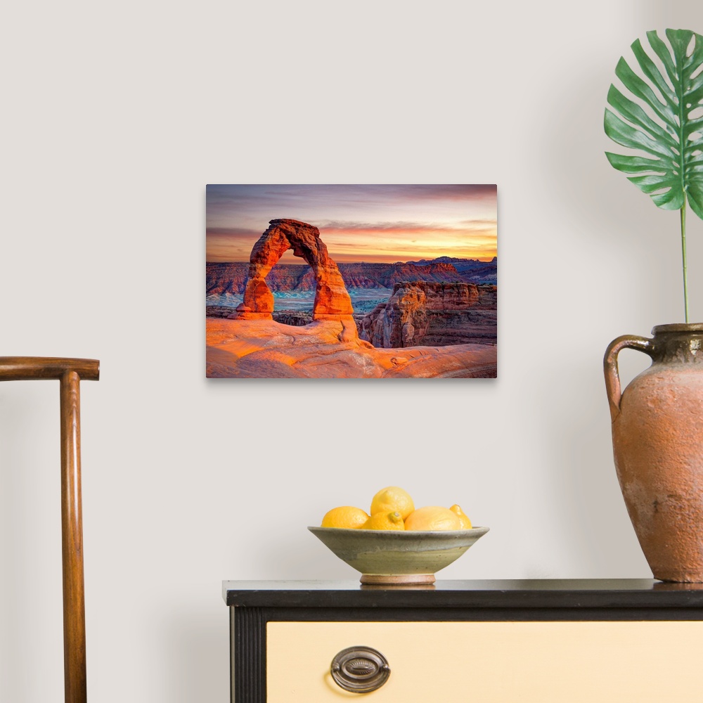 A traditional room featuring This wall art for the home or office shows desert rock cliffs growing in the light of a sunset.