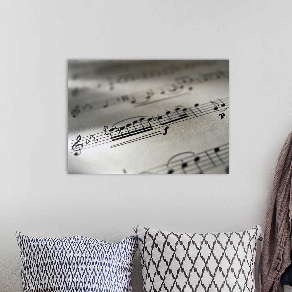 A bohemian room featuring Large canvas photo of the up close view of a music sheet with musical notes.