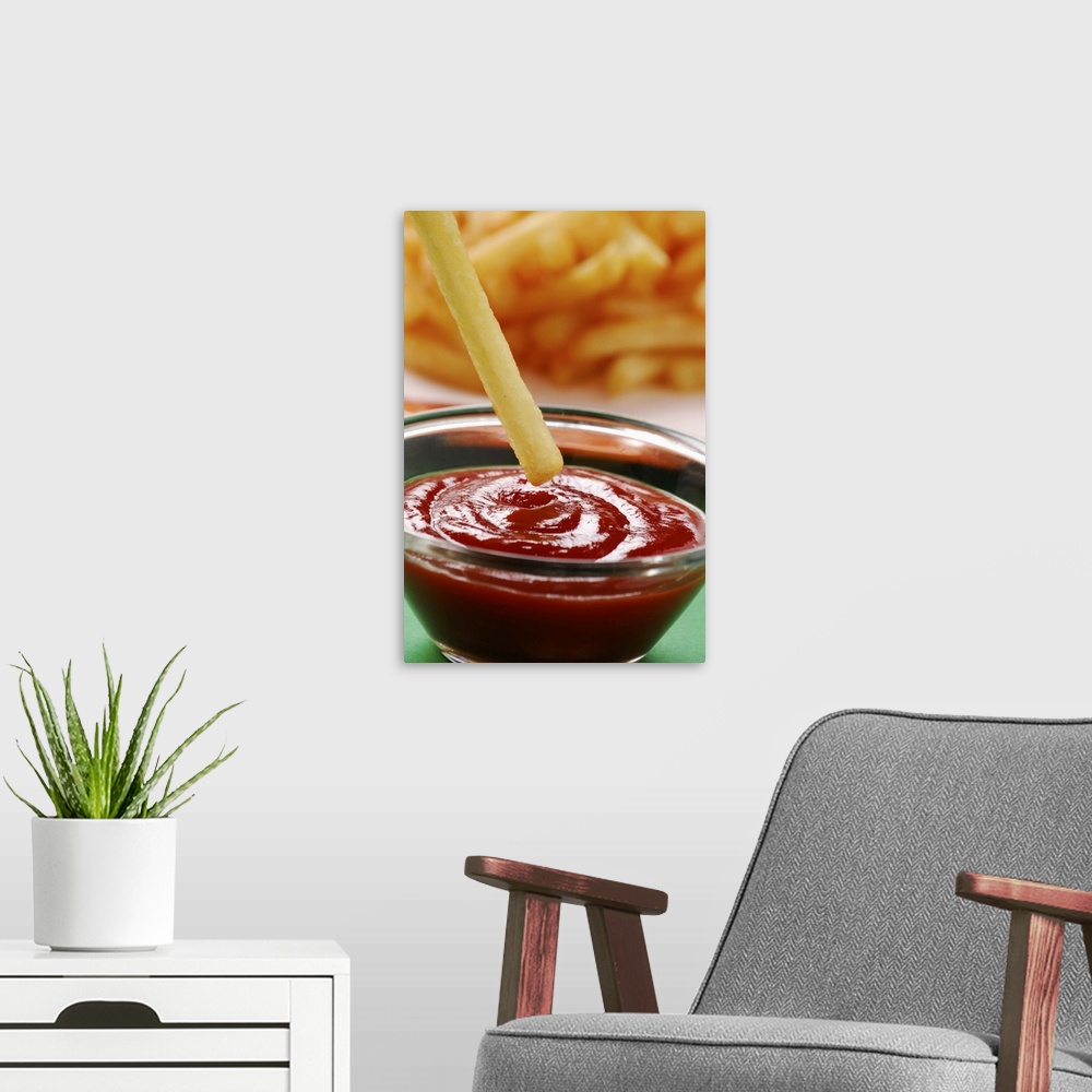 A modern room featuring Dipping French fries in ketchup, close up