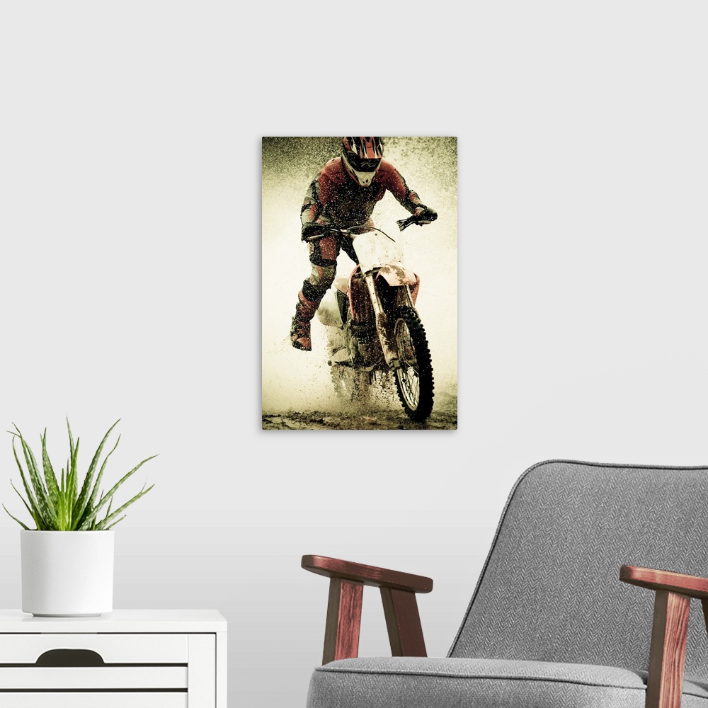 A modern room featuring Dirt bike rider splashes through water filled stream during race event sending him off bikes seat...