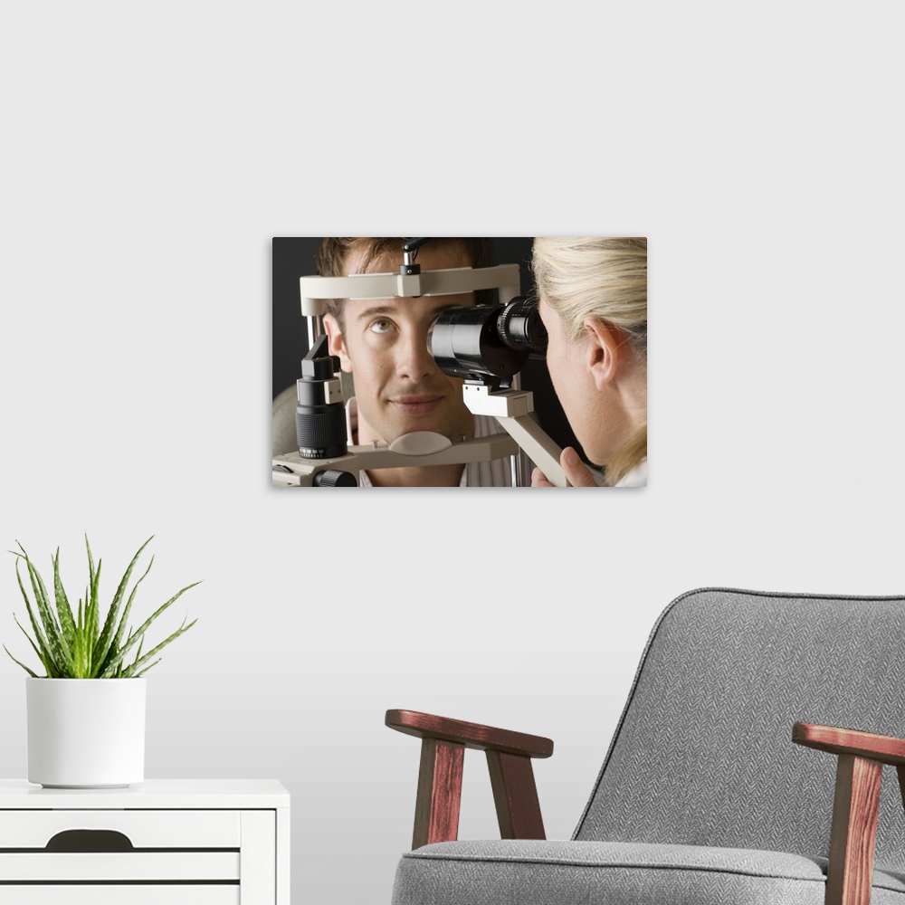 A modern room featuring Doctor looking at eye with slit lamp