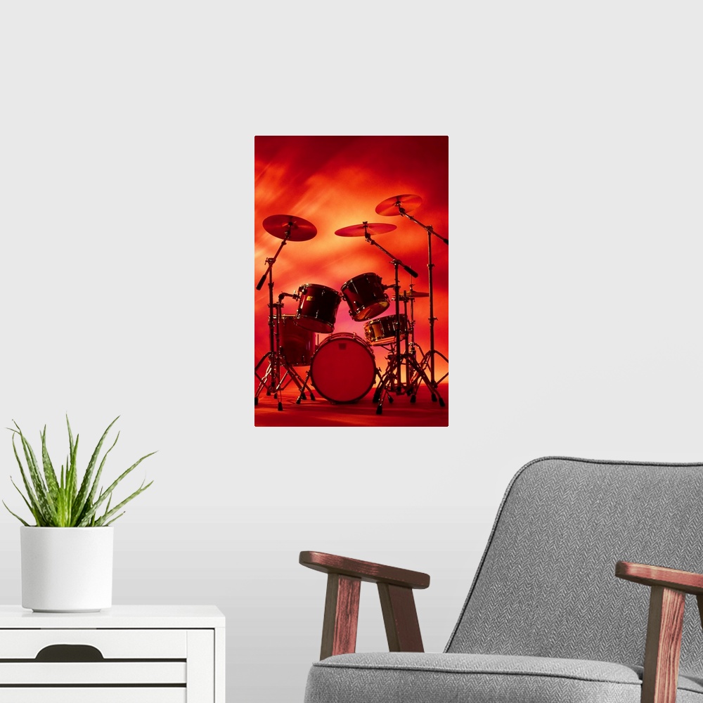 A modern room featuring Large vertical photograph of a drum set with symbols, surrounded by warm, fiery lighting.
