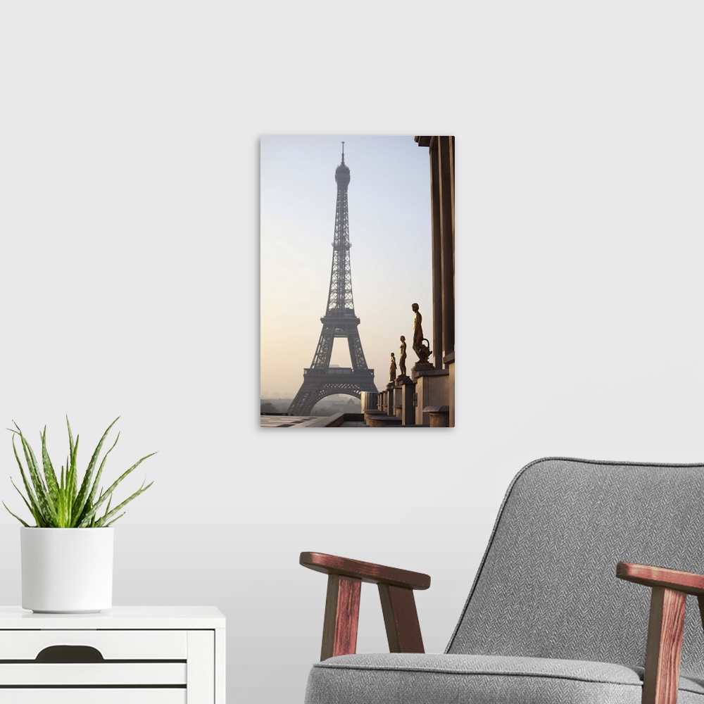 A modern room featuring Eiffel tower with statues in the foreground