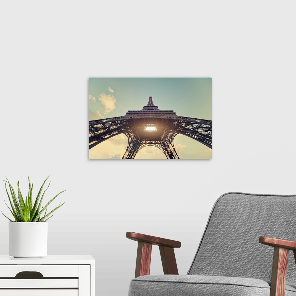 A modern room featuring Eiffel Tower with sun shining through center.
