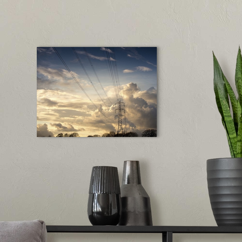 A modern room featuring Electric high power lines against beautiful cloud formation.
