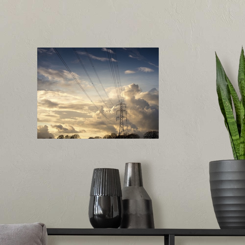 A modern room featuring Electric high power lines against beautiful cloud formation.
