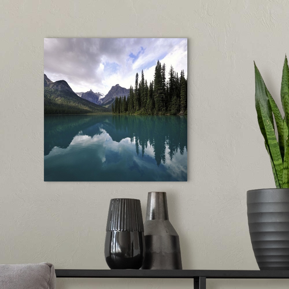 A modern room featuring Clouds over mountain and trees with reflection in Emerald lake, Alberta Canada.