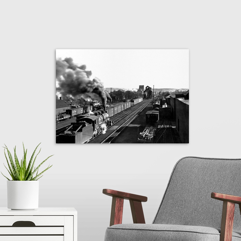 A modern room featuring A locomotive pours smoke as it travels through the railroad yard in Minot, North Dakota.
