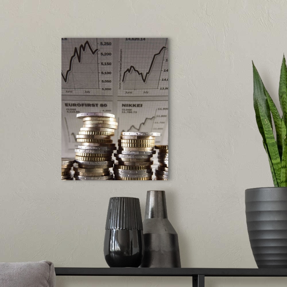 A modern room featuring Euro Currency: Unevenly stacked coins, financial graphs in background