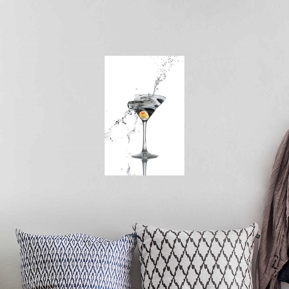 A bohemian room featuring A shattering martini glass on a white background spraying liquid outward.
