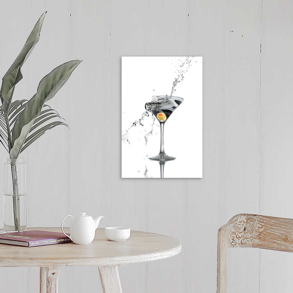 A farmhouse room featuring A shattering martini glass on a white background spraying liquid outward.
