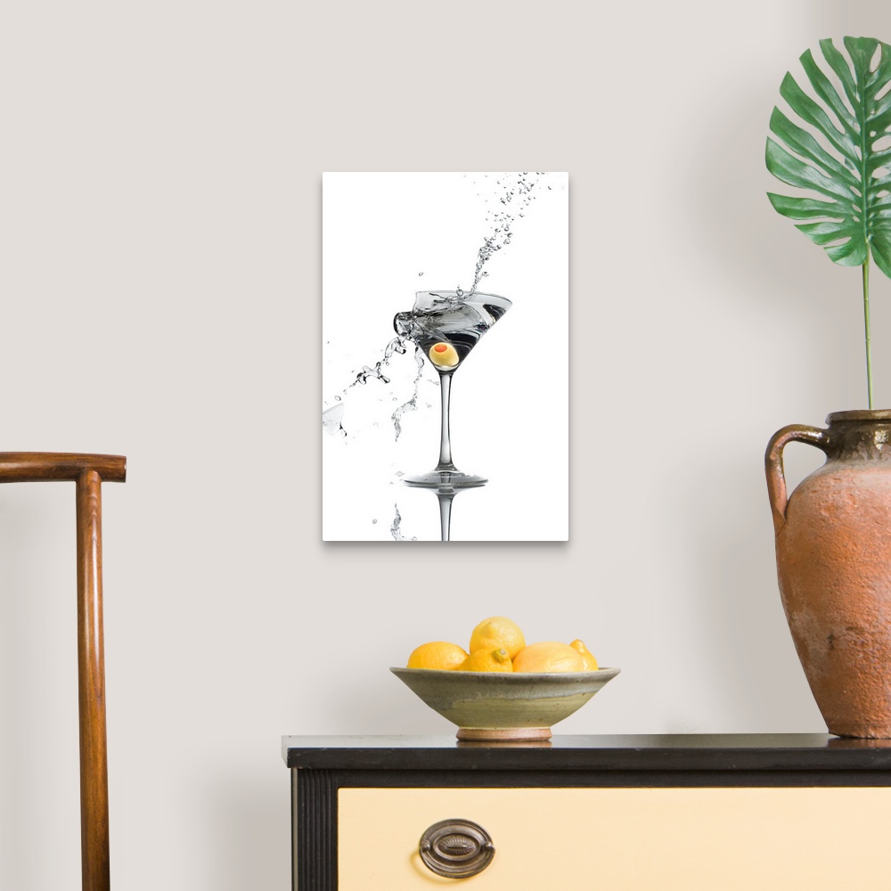 A traditional room featuring A shattering martini glass on a white background spraying liquid outward.