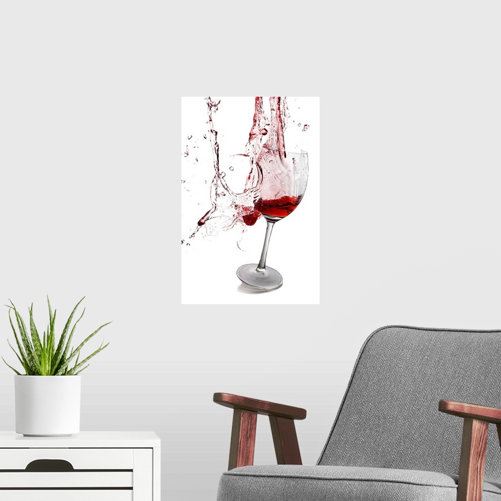 A modern room featuring Portrait photograph on a large wall hanging of a slightly tilted glass of red wine, the goblet ap...