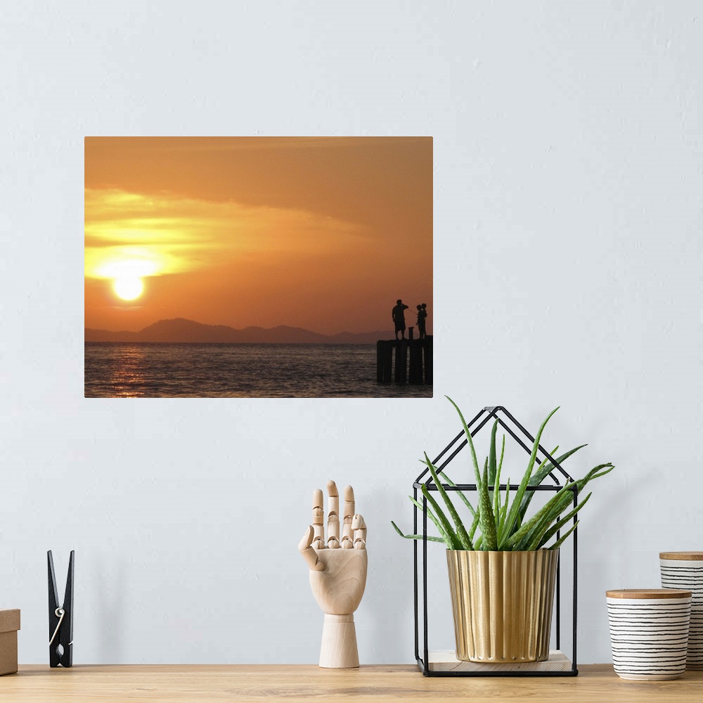 A bohemian room featuring Family watching sunset from jetty in Malaysia.