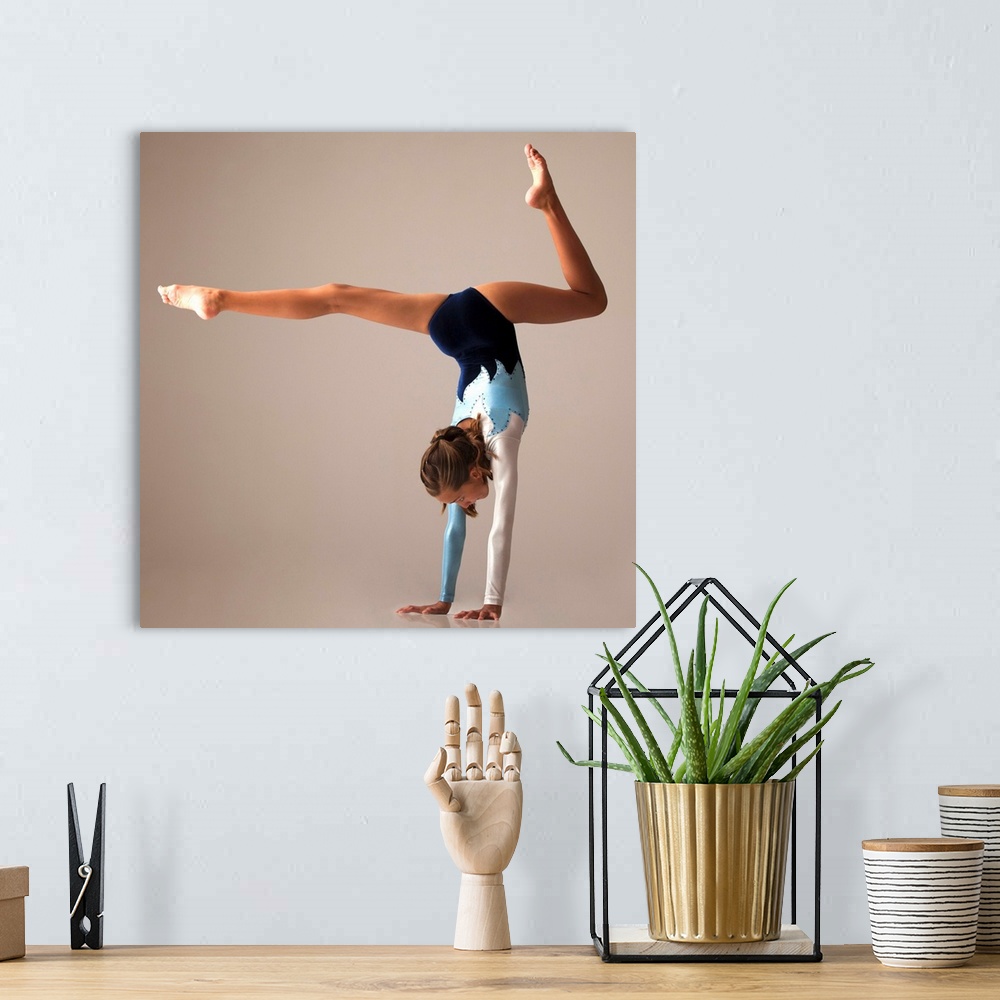 A bohemian room featuring Female gymnast (12-13) performing handstand