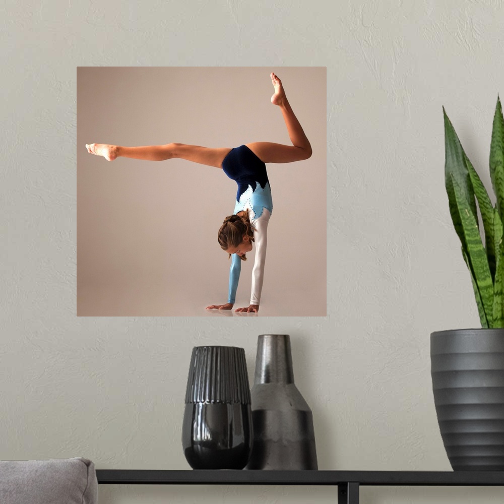 A modern room featuring Female gymnast (12-13) performing handstand