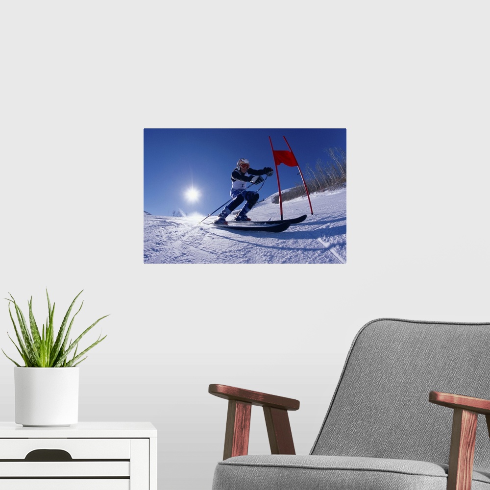 A modern room featuring Female skier skiing around red gate, low angle view