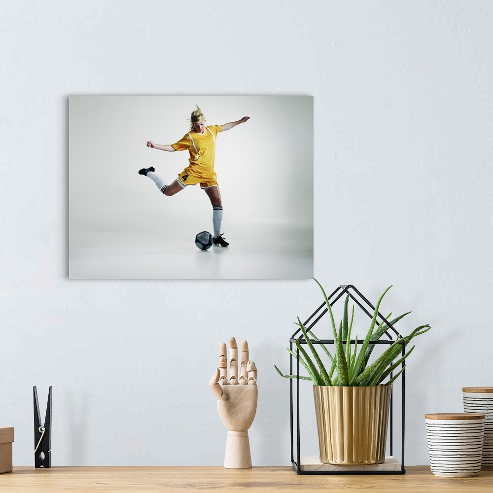 A bohemian room featuring Female soccer player preparing to kick soccer ball