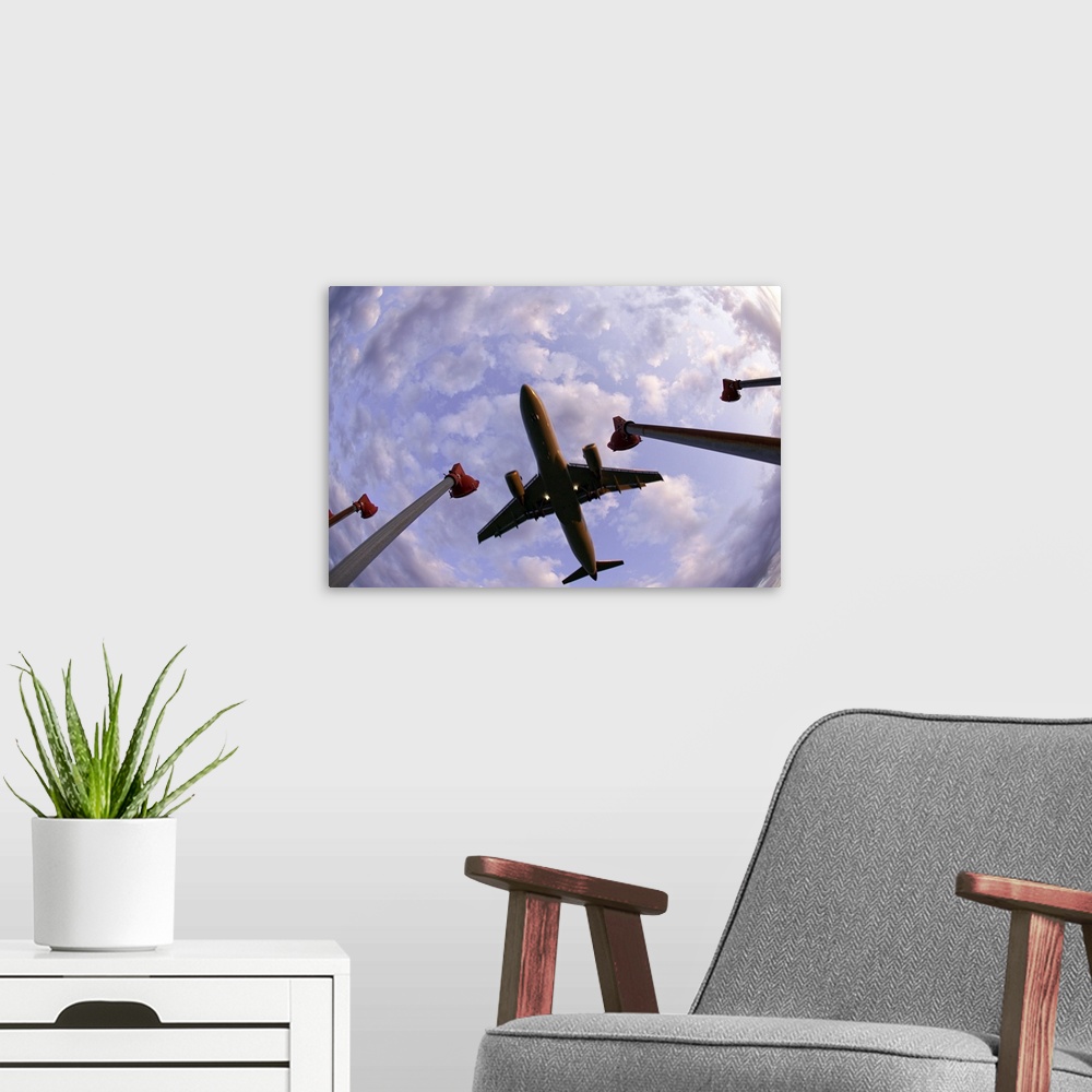 A modern room featuring Fisheye wide shot of an airplane landing directly over the viewer