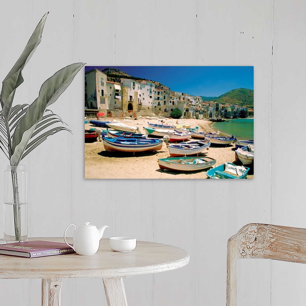 A farmhouse room featuring Huge photograph showcases a fleet of small water vessels sitting on top of a sandy beach within t...