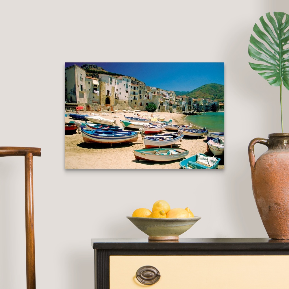 A traditional room featuring Huge photograph showcases a fleet of small water vessels sitting on top of a sandy beach within t...