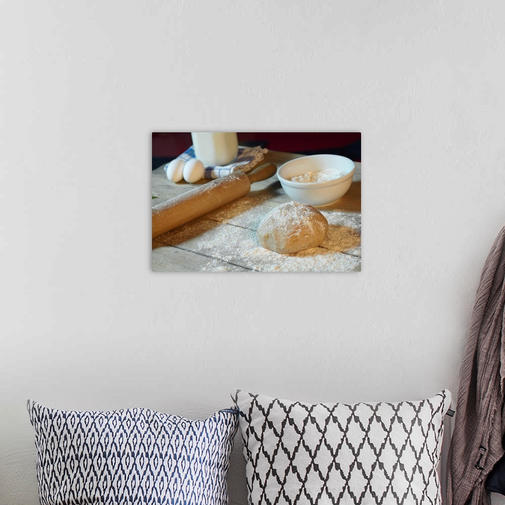 A bohemian room featuring Large horizontal photograph of bread dough in ball on a wooden table, sprinkled with flour.  Obje...