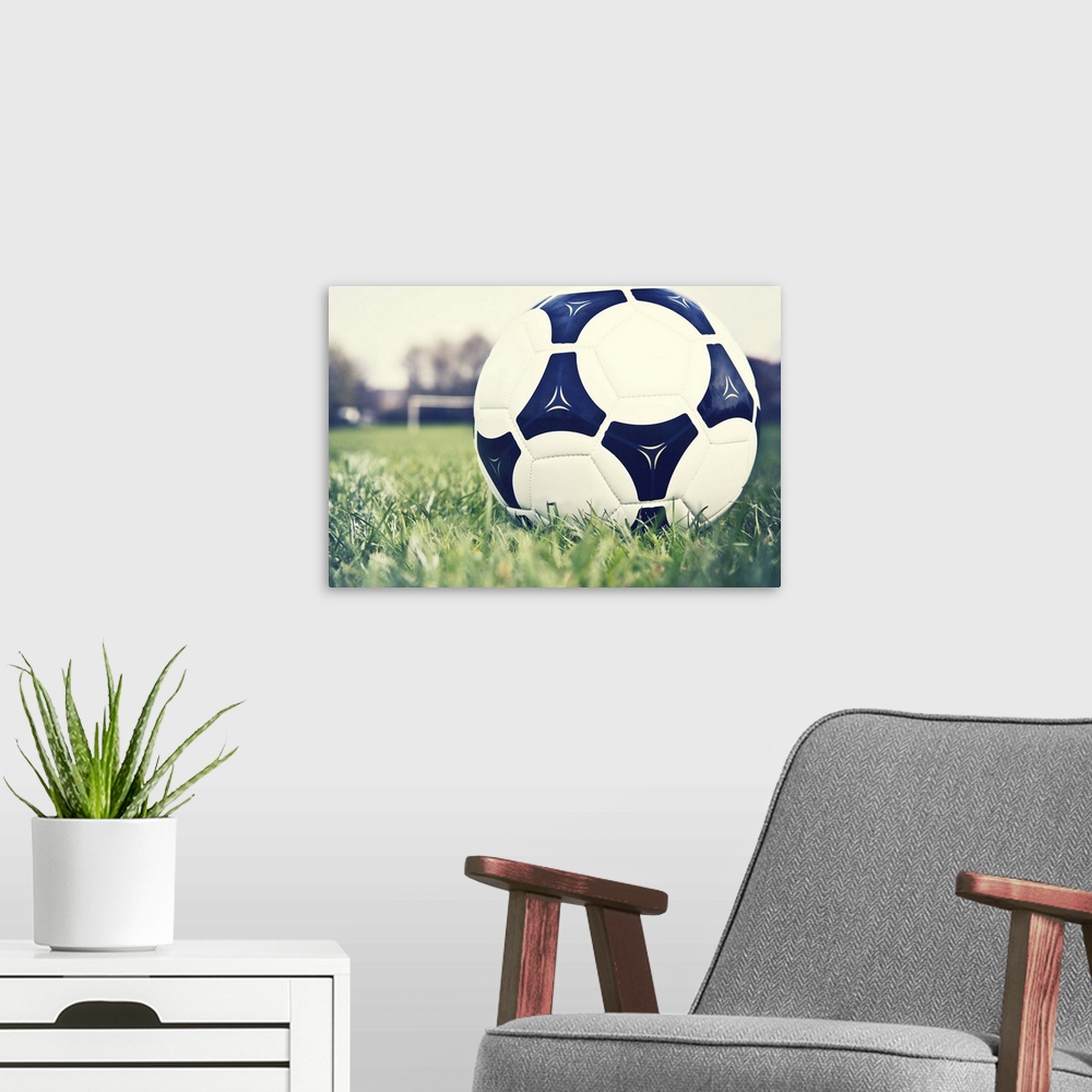 A modern room featuring Football on football pitch with goal in distance.